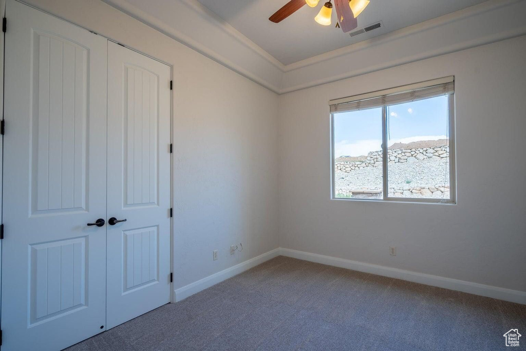 Unfurnished bedroom with carpet, a closet, visible vents, and baseboards