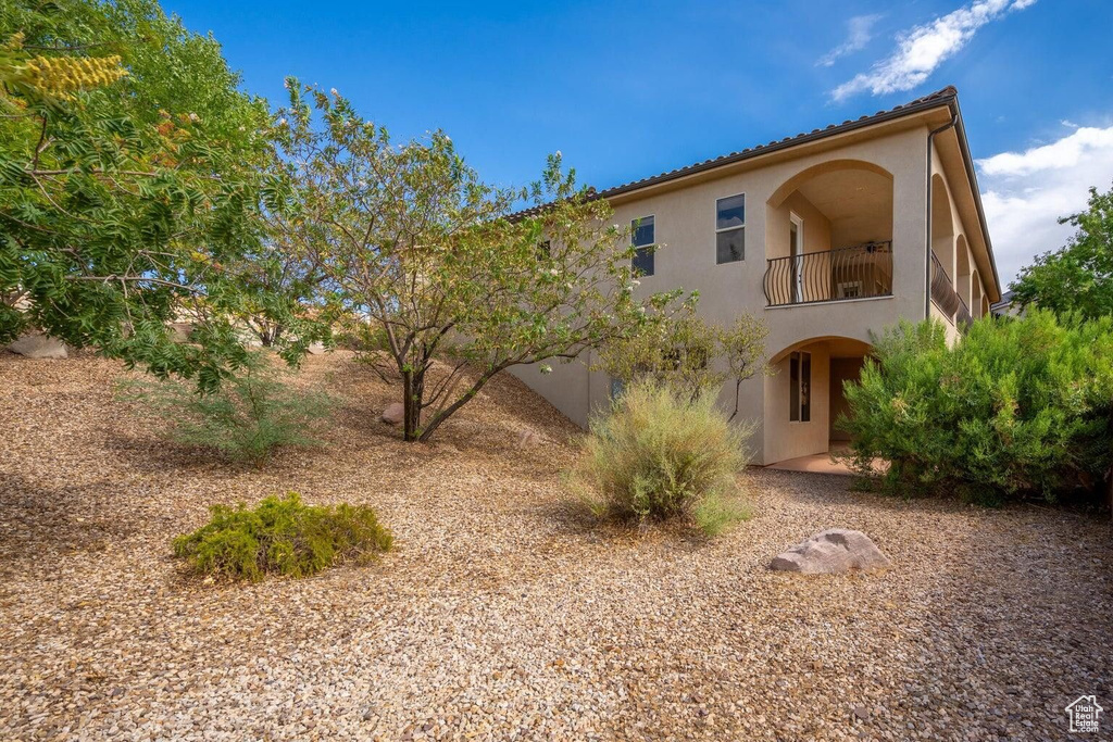 Rear view of house with a balcony and stucco siding