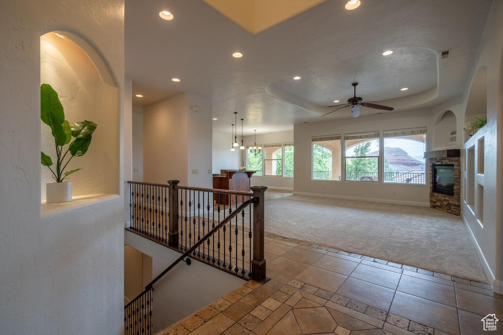 Interior space featuring baseboards, a raised ceiling, tile patterned floors, a fireplace, and recessed lighting