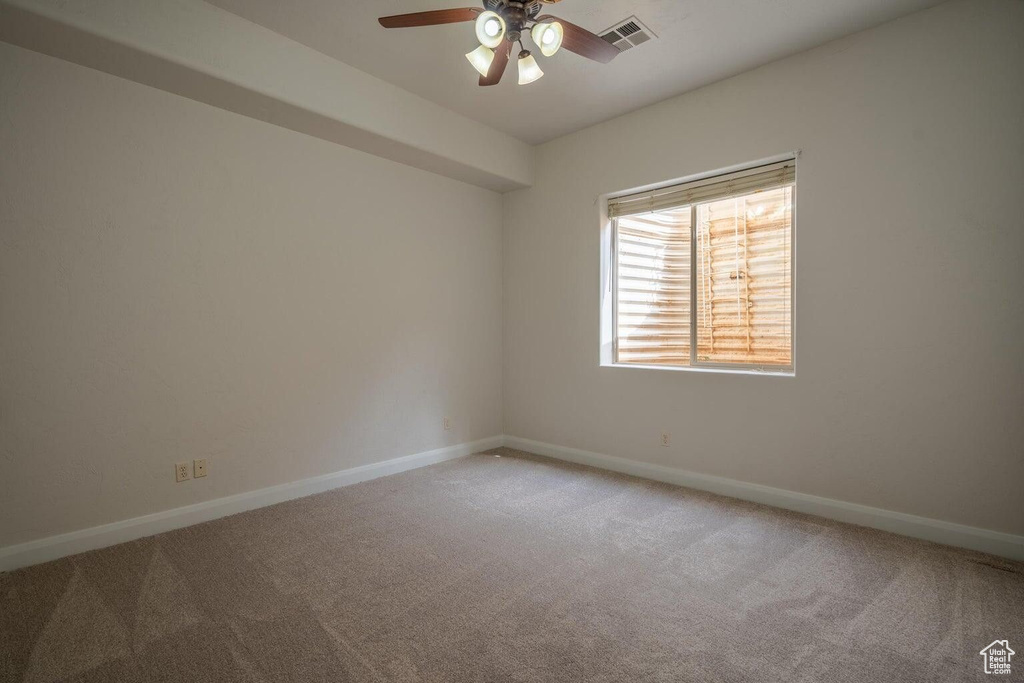Spare room with visible vents, light carpet, and baseboards