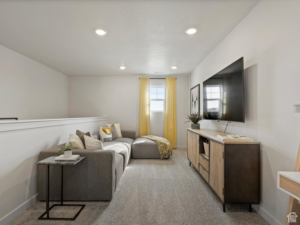 Living area featuring recessed lighting, light colored carpet, and baseboards