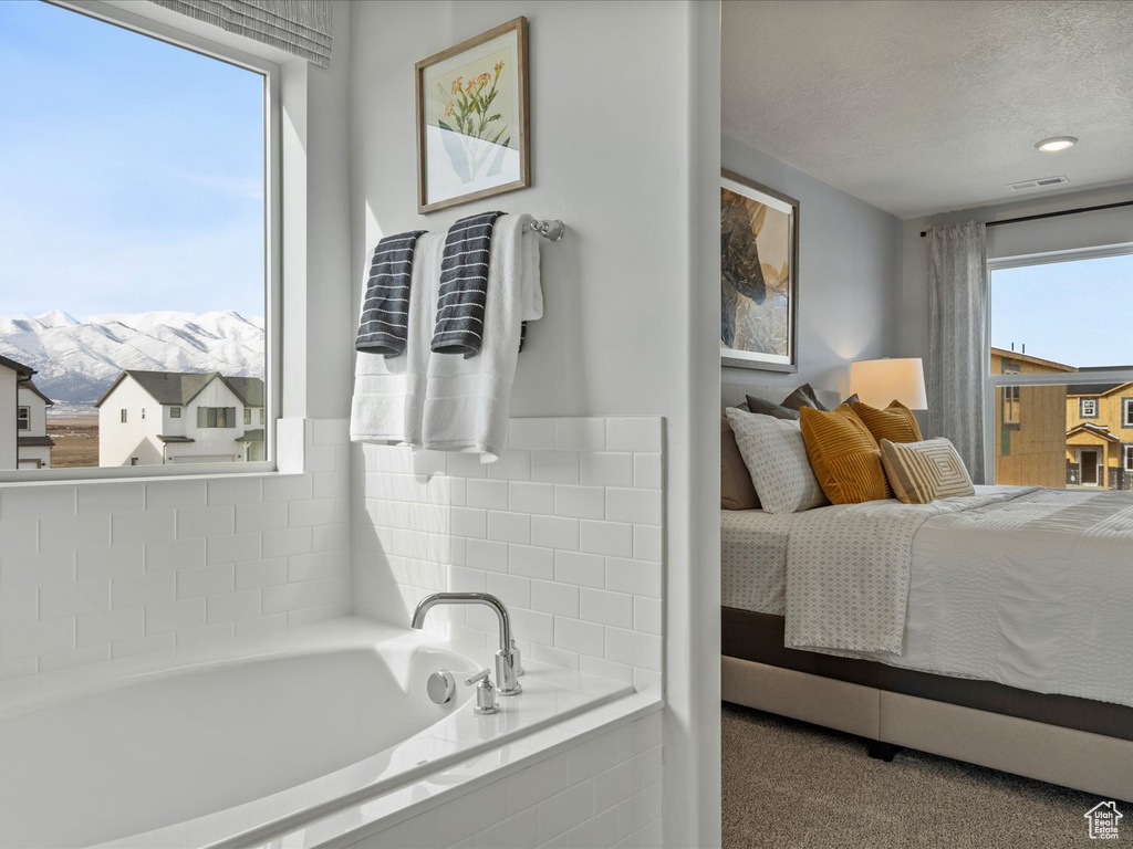 Bedroom with visible vents, multiple windows, a mountain view, and a textured ceiling