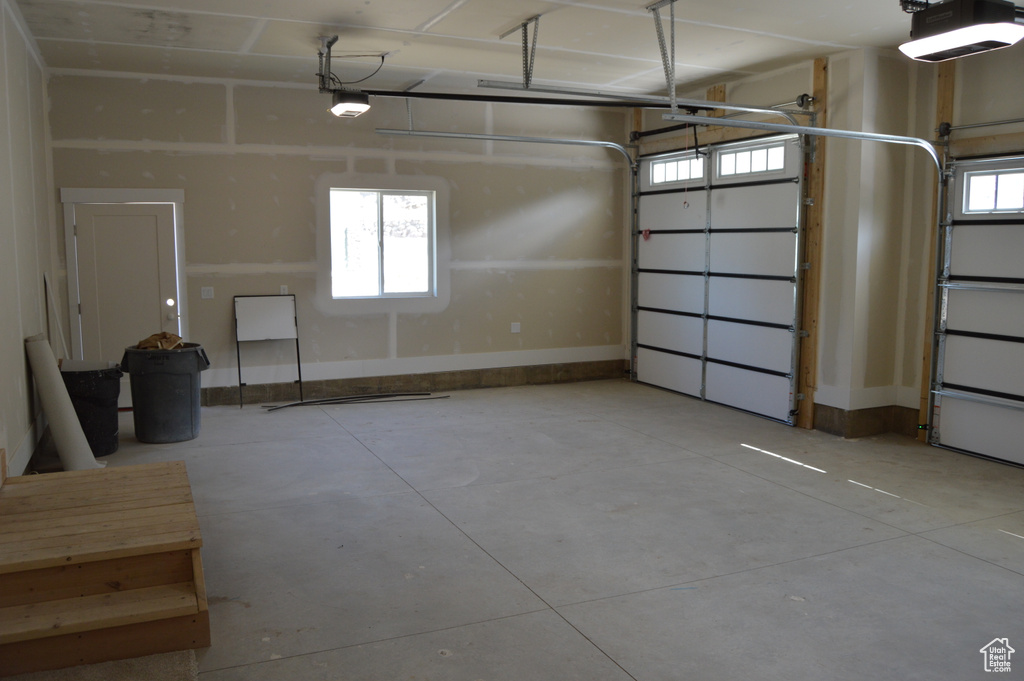 Garage with a garage door opener and baseboards
