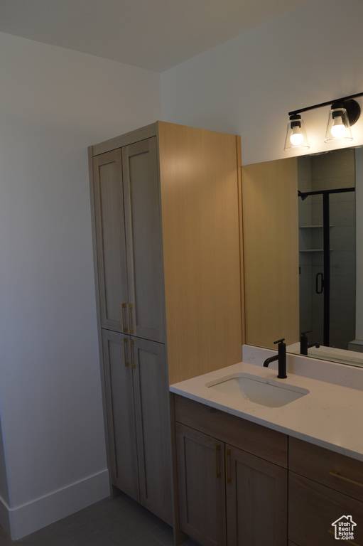 Bathroom with vanity, a shower stall, and tile patterned flooring