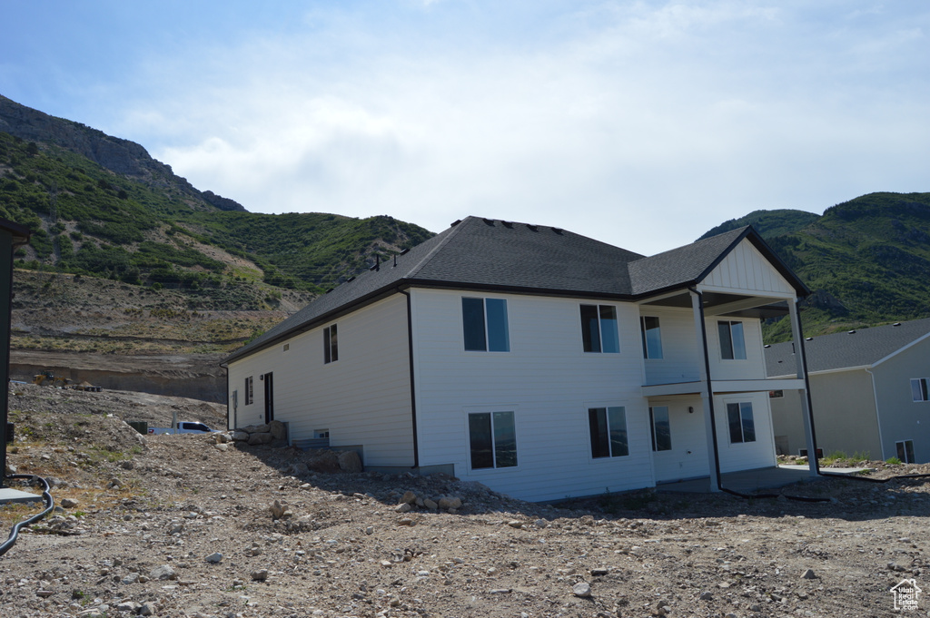View of home's exterior with a mountain view and a shingled roof