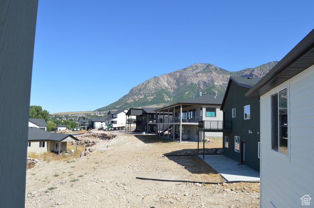 View of yard with a mountain view, a balcony, a residential view, and a patio