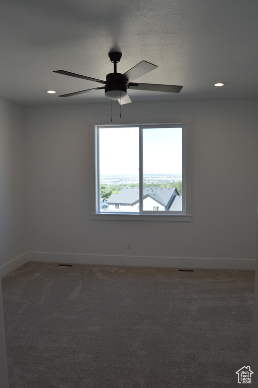 Unfurnished room featuring ceiling fan, light carpet, healthy amount of natural light, and recessed lighting