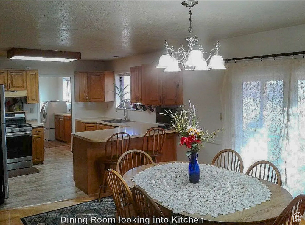 Dining room featuring a textured ceiling and an inviting chandelier