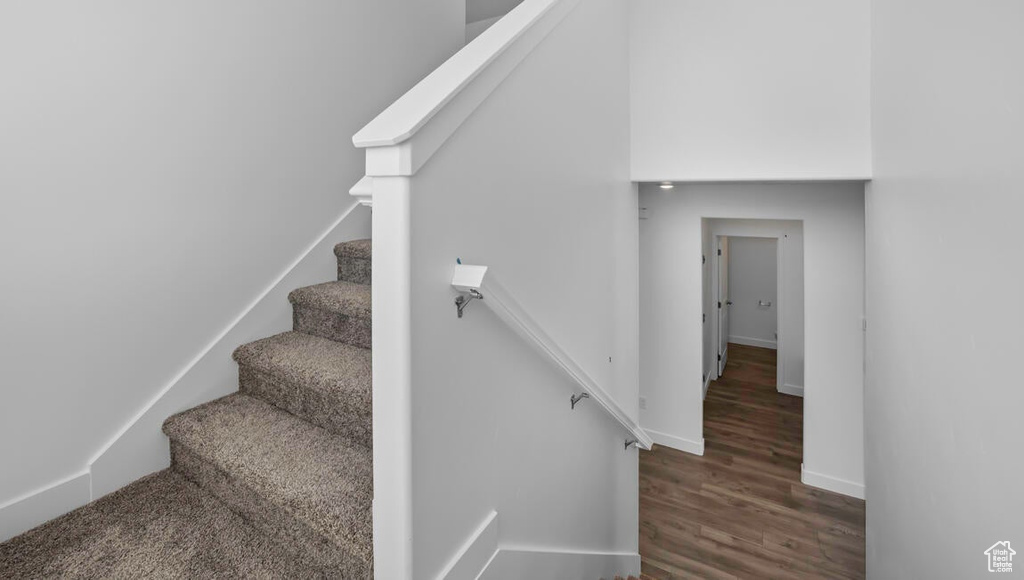 Staircase featuring baseboards and wood finished floors