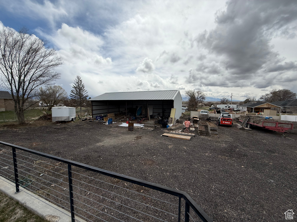 View of vehicle parking with an outbuilding and fence