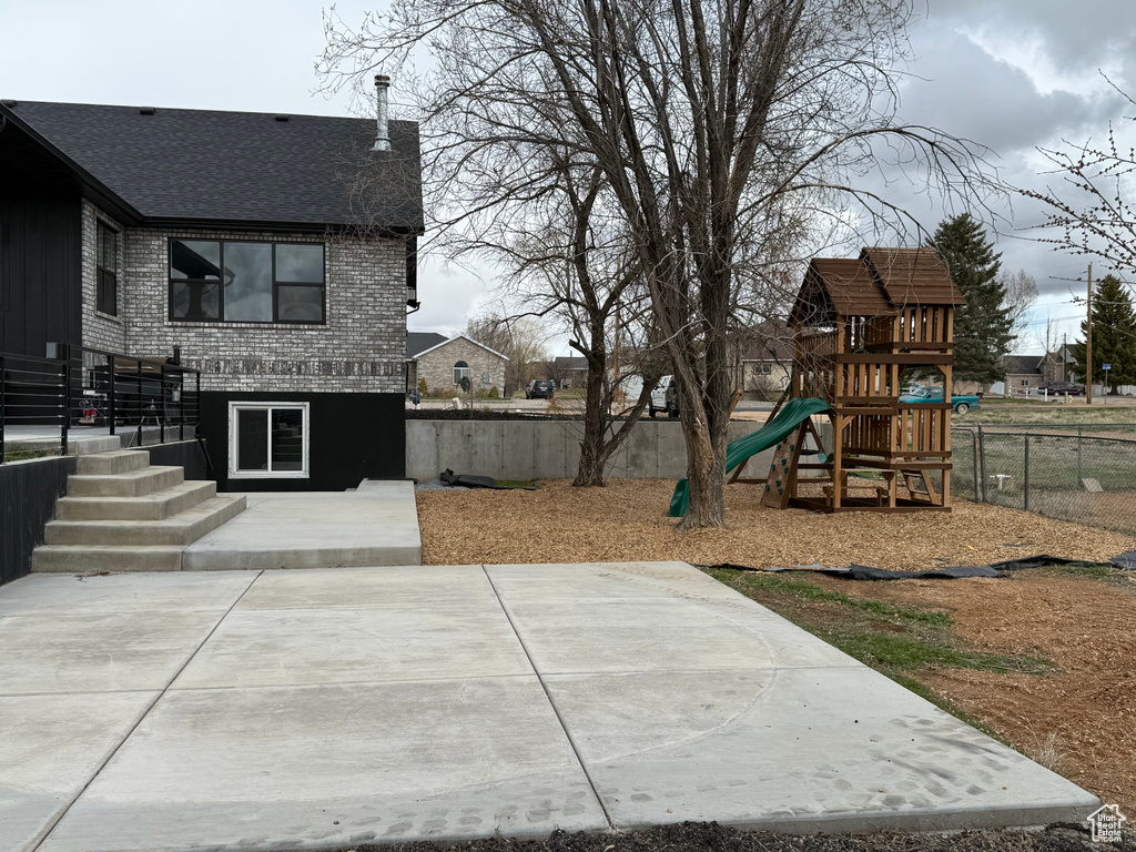 View of yard with a fenced backyard, playground community, and a patio area