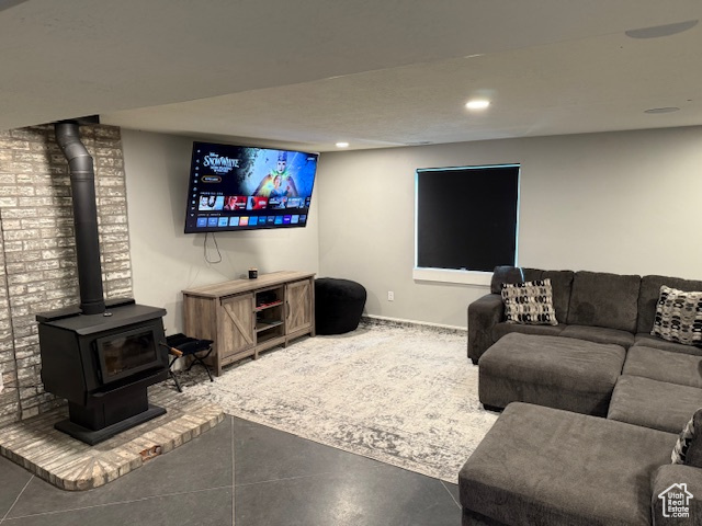 Living room with a wood stove, recessed lighting, and concrete flooring