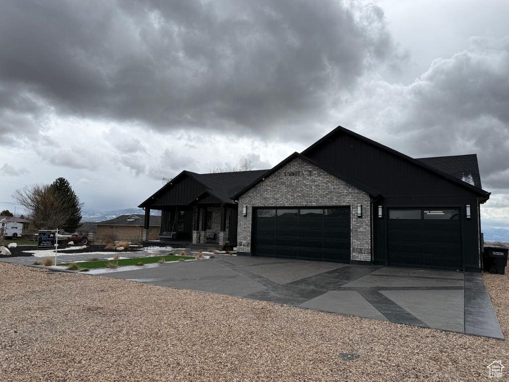 View of front of house with an attached garage, brick siding, and concrete driveway