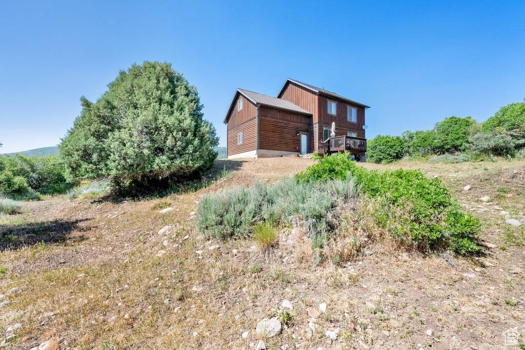 View of side of property with a wooden deck
