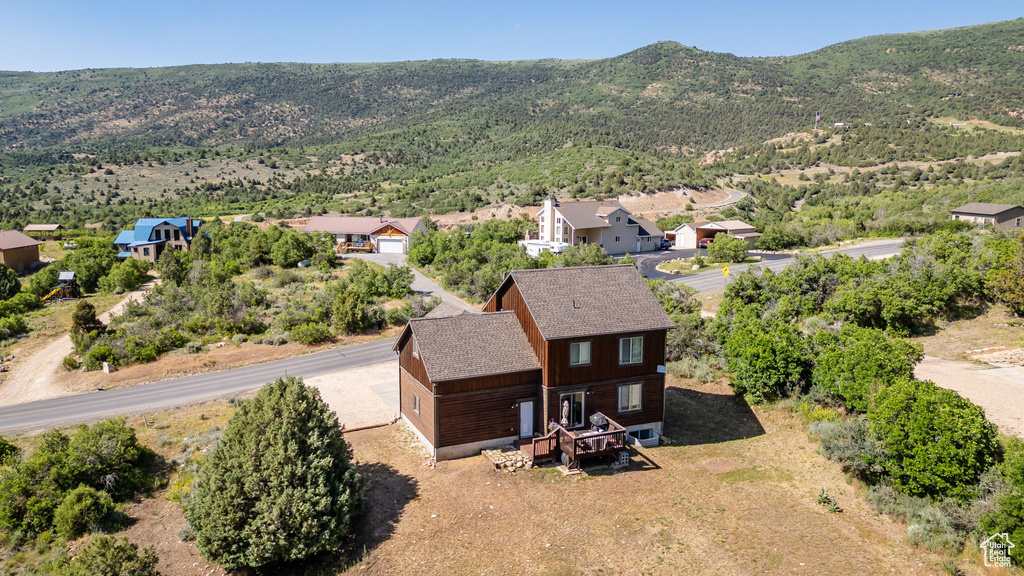Aerial view of property and surrounding area with a mountainous background