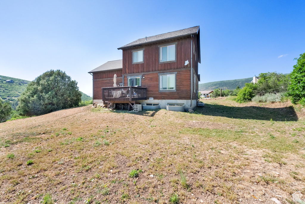 Back of property with a deck and a yard