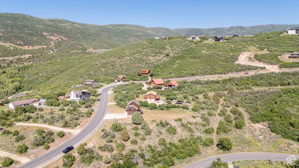 Aerial view of property and surrounding area with a mountain backdrop