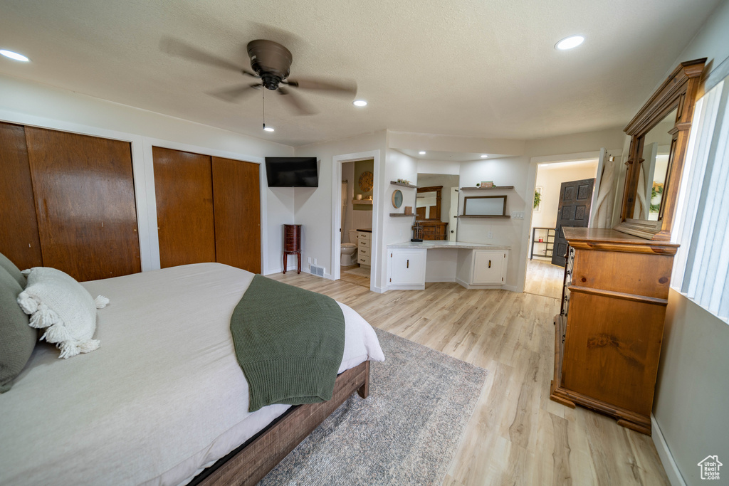 Bedroom featuring baseboards, light wood-style flooring, recessed lighting, and two closets
