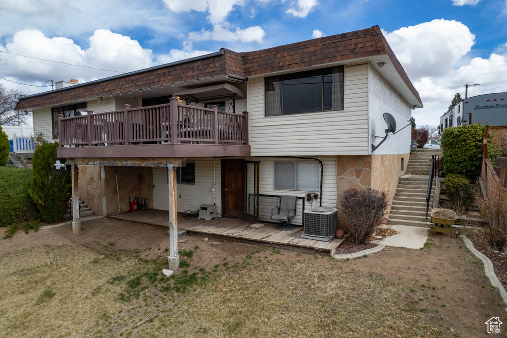 Back of house featuring stairs, a shingled roof, central AC, and a wooden deck
