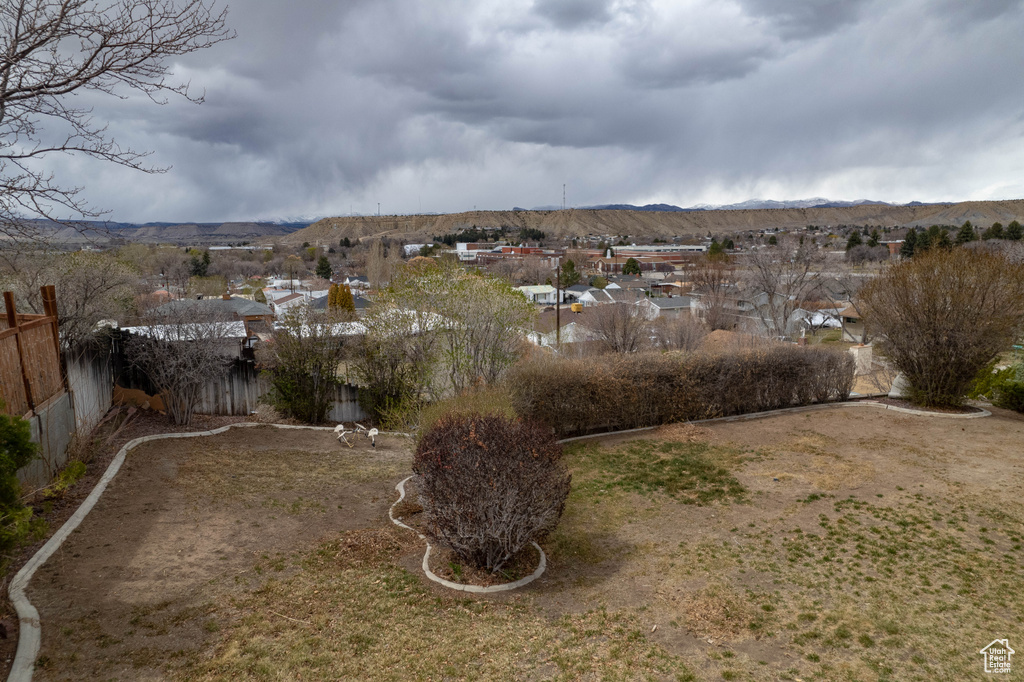 View of yard with a mountain view and fence
