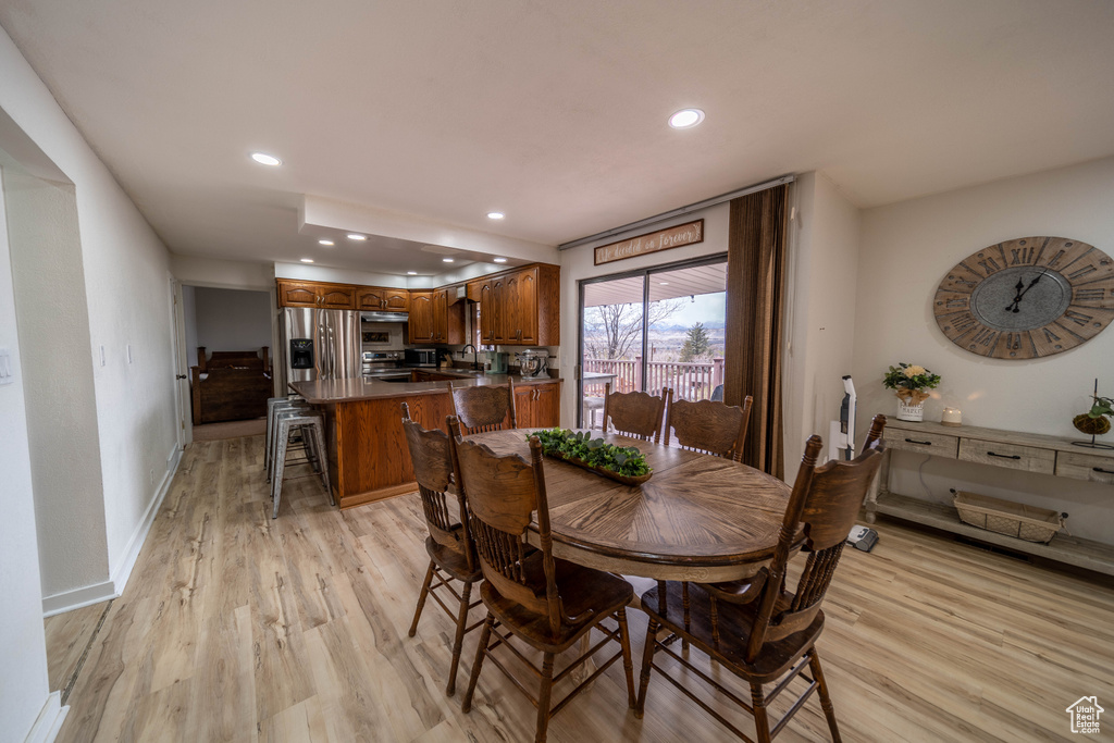 Dining area featuring baseboards, recessed lighting, and light wood-type flooring