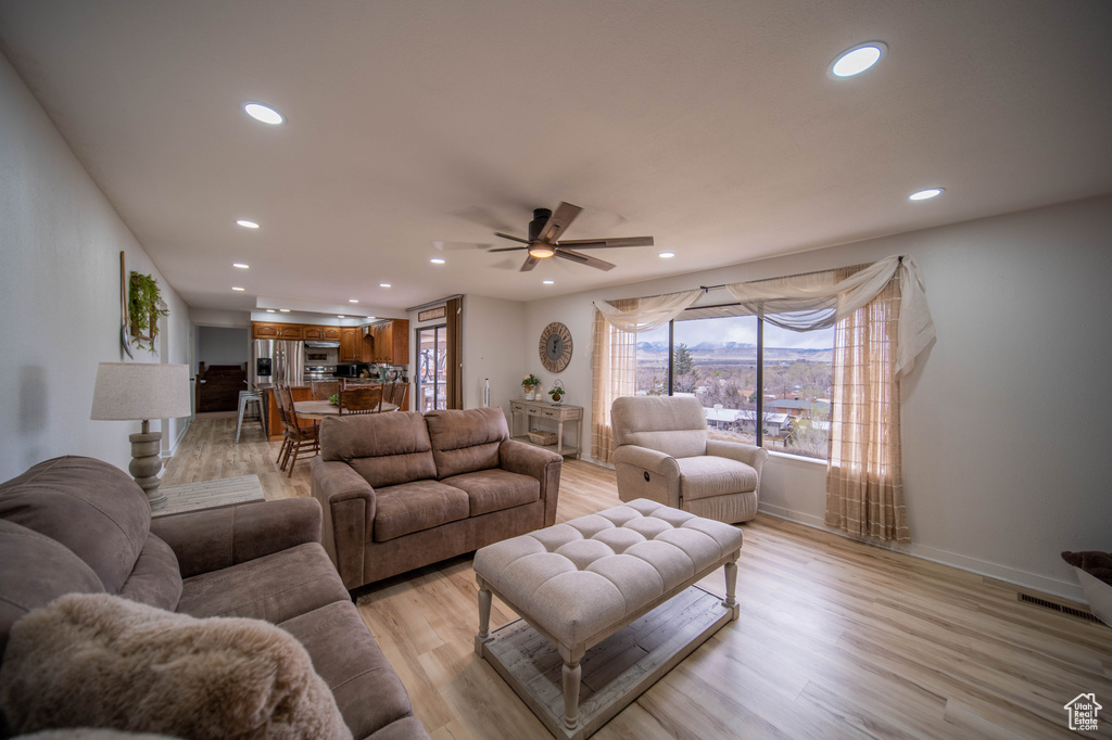 Living room with baseboards, light wood-style flooring, recessed lighting, and a ceiling fan