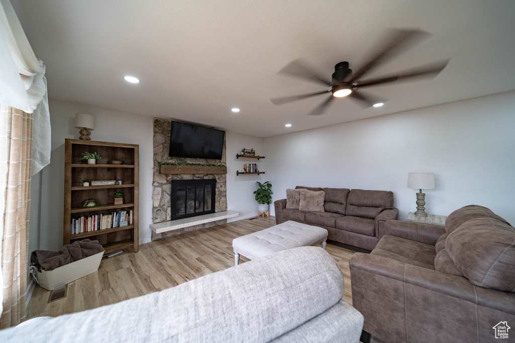 Living area with recessed lighting, ceiling fan, visible vents, a fireplace, and wood finished floors