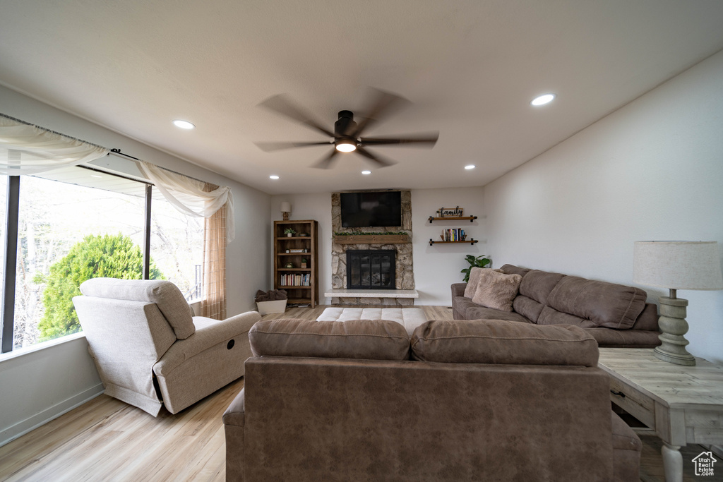 Living room with a fireplace, recessed lighting, a ceiling fan, and light wood finished floors