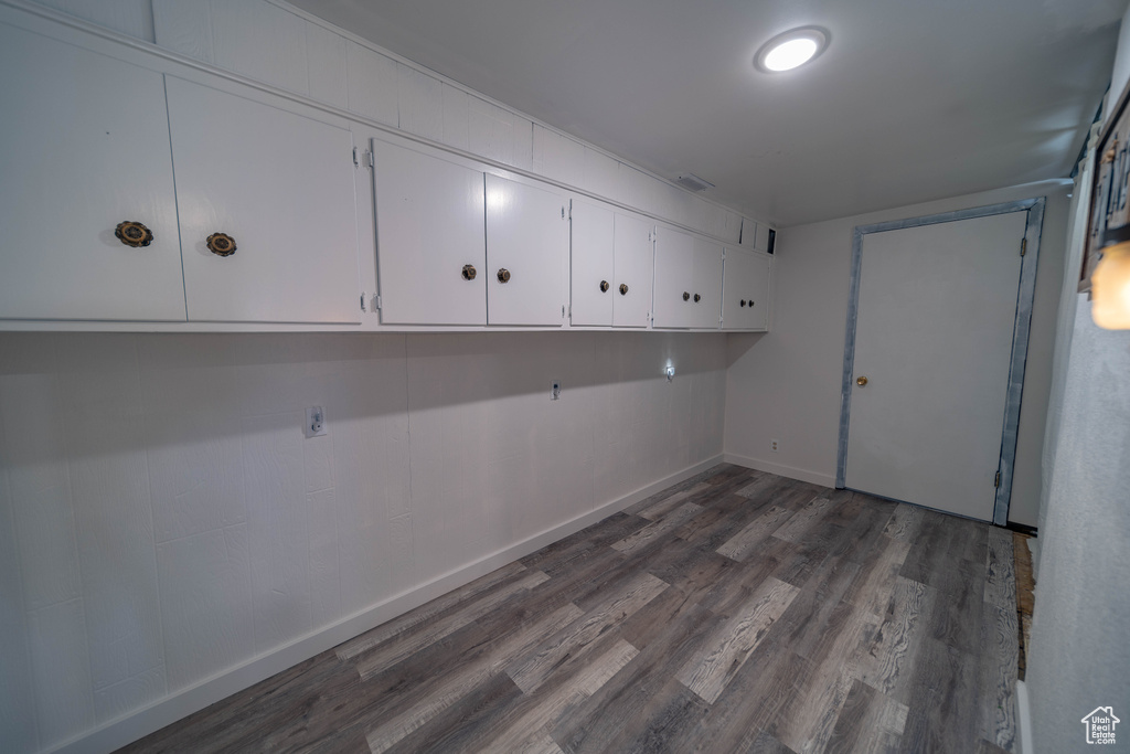 Laundry area featuring baseboards and dark wood-style floors