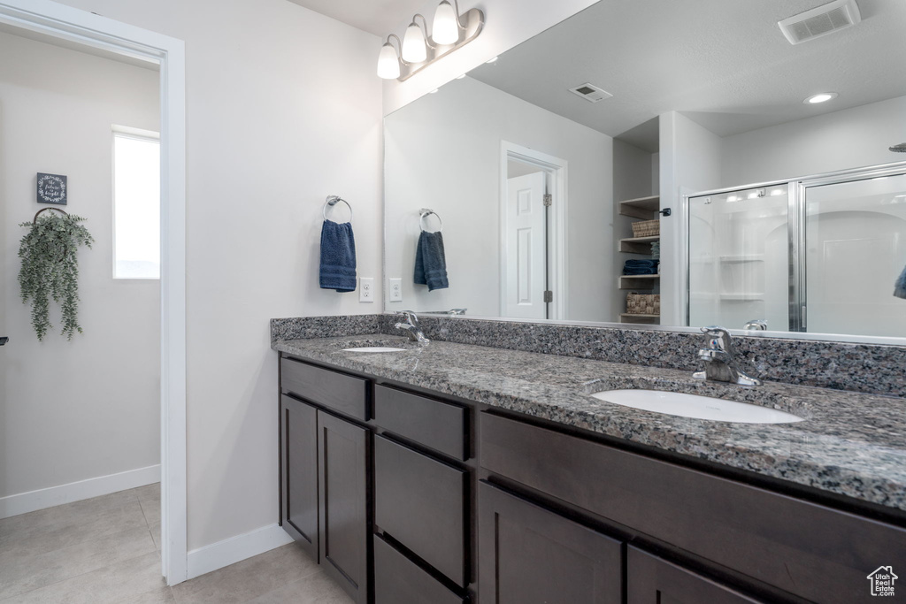 Bathroom with visible vents, a sink, and a stall shower