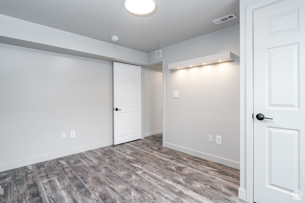 Interior space with baseboards, visible vents, and wood finished floors