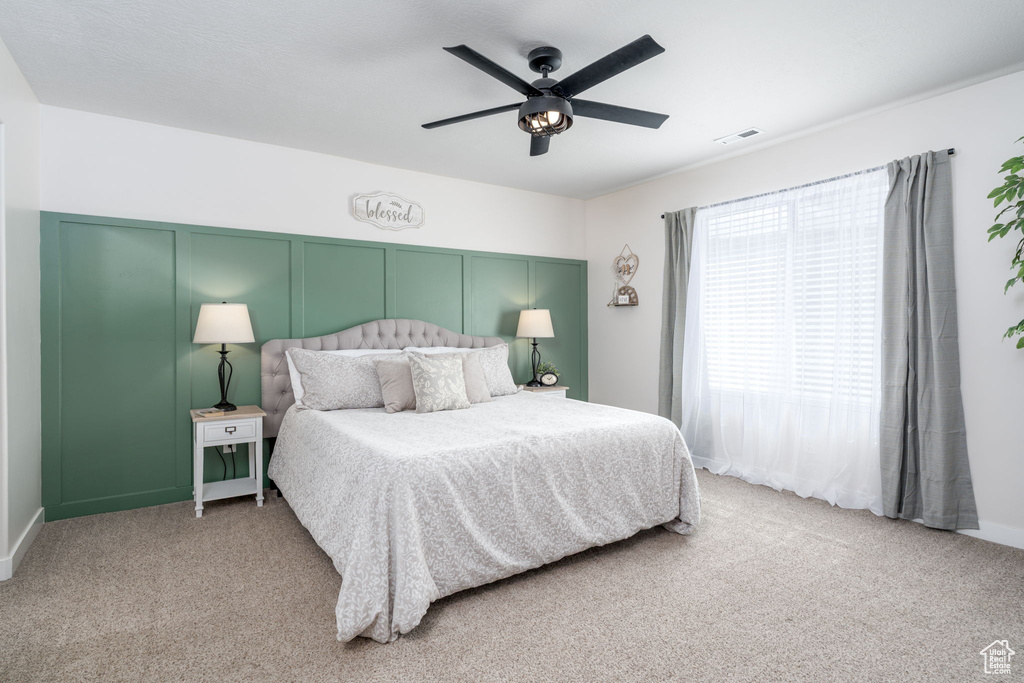Carpeted bedroom with ceiling fan and visible vents