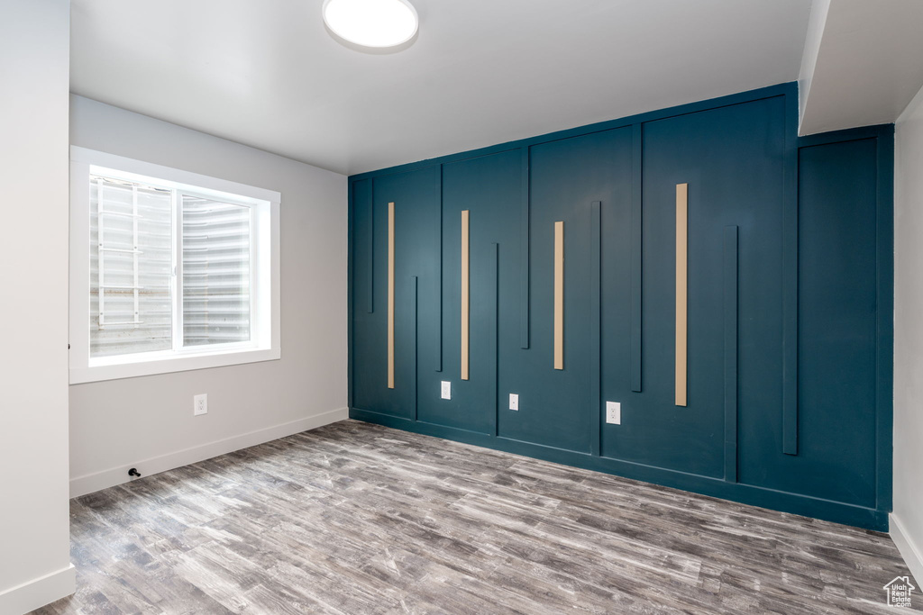 Unfurnished bedroom with baseboards and wood finished floors