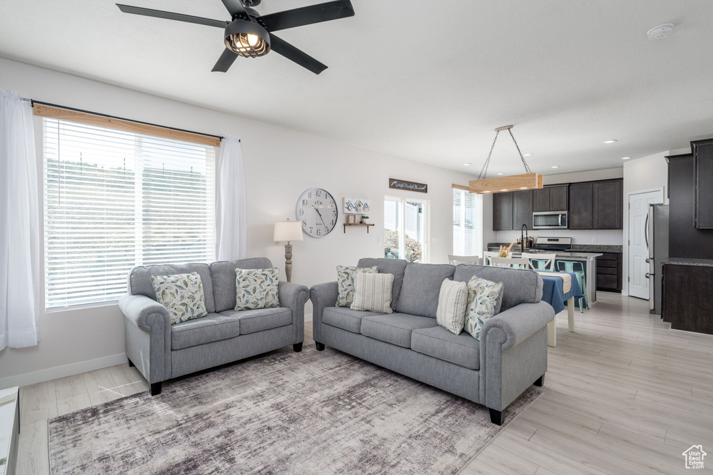 Living area with baseboards, light wood-style floors, recessed lighting, and a ceiling fan