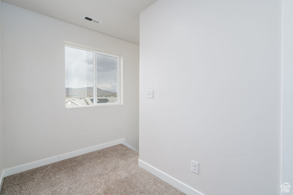 Spare room with baseboards, visible vents, and carpet