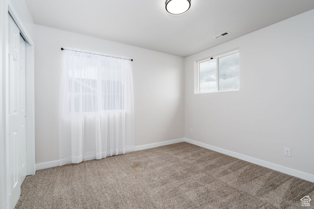 Unfurnished bedroom featuring baseboards, visible vents, a closet, and carpet