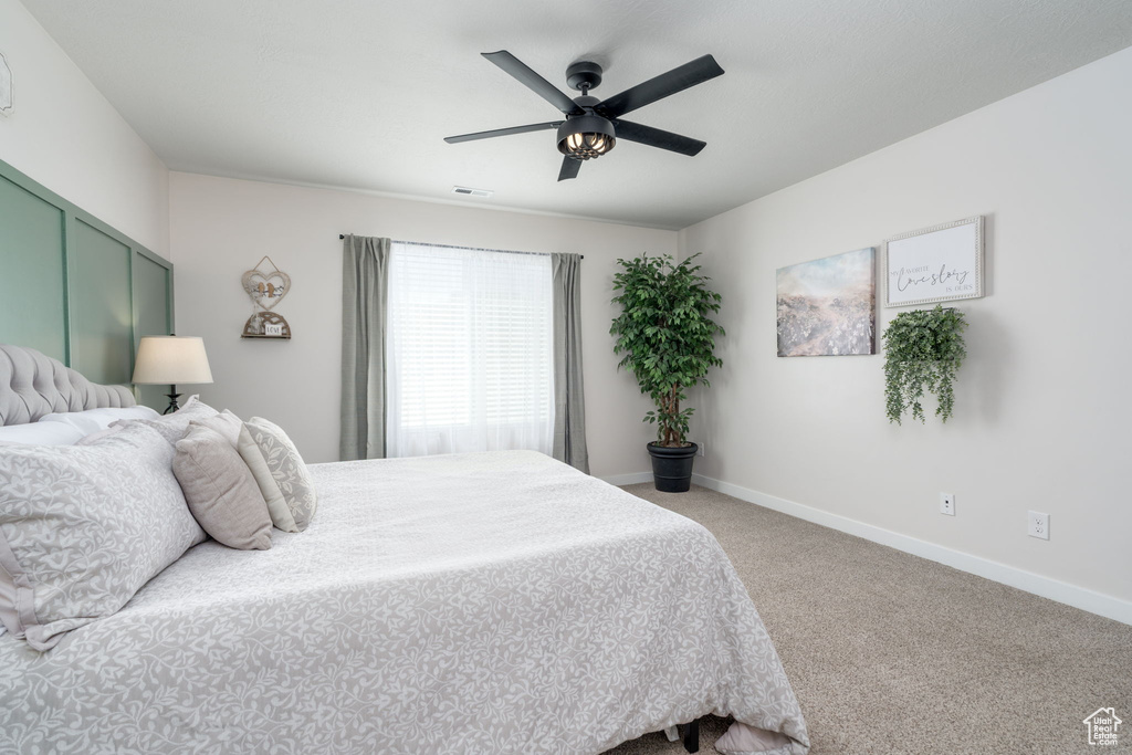 Bedroom featuring baseboards, ceiling fan, visible vents, and carpet