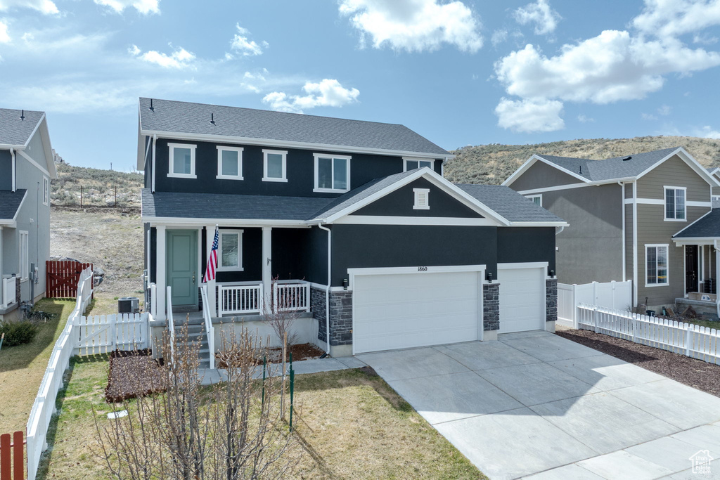 View of front of house featuring fence, a garage, concrete driveway, roof with shingles, and a porch