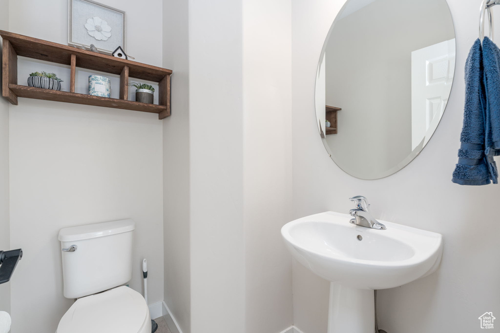 Bathroom with a sink, baseboards, and toilet