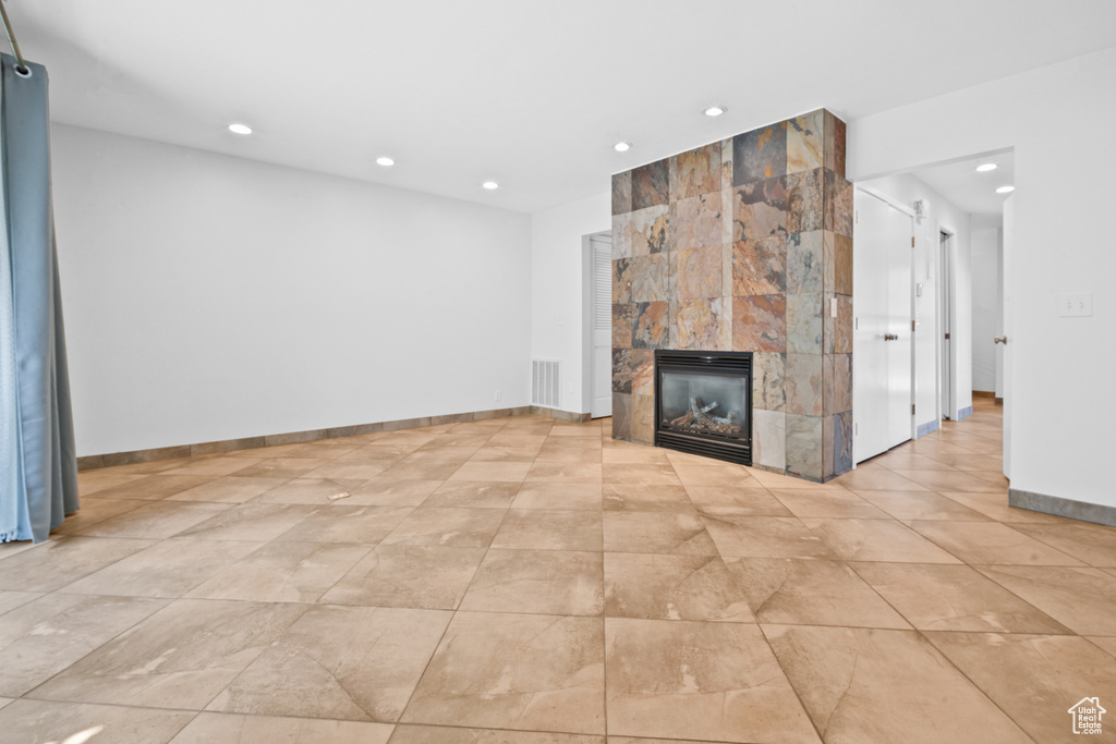 Unfurnished living room featuring recessed lighting and a large fireplace