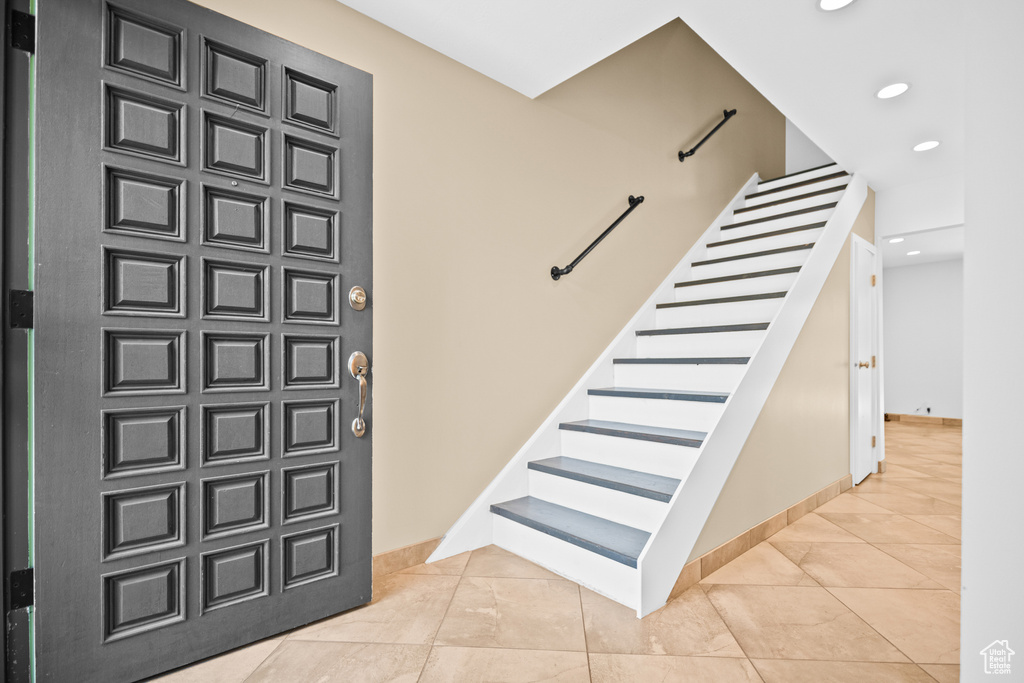 Tiled entrance foyer featuring stairs and recessed lighting