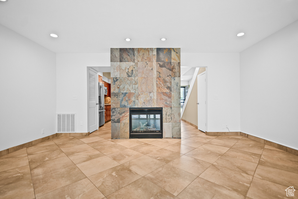 Unfurnished living room with recessed lighting and a multi sided fireplace