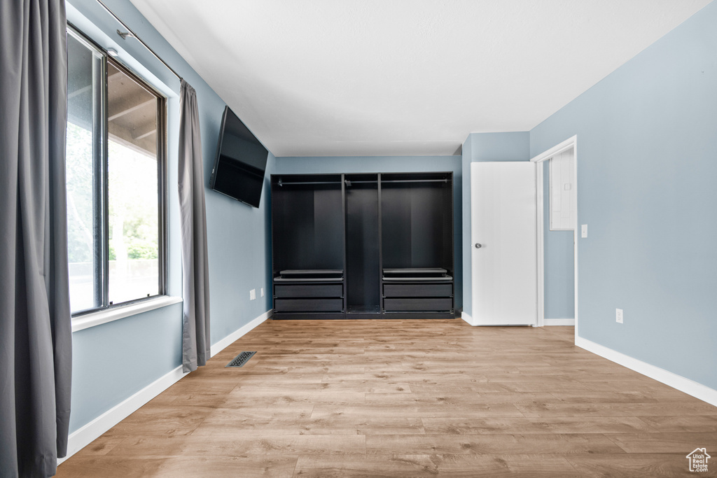 Unfurnished bedroom with wood finished floors and baseboards