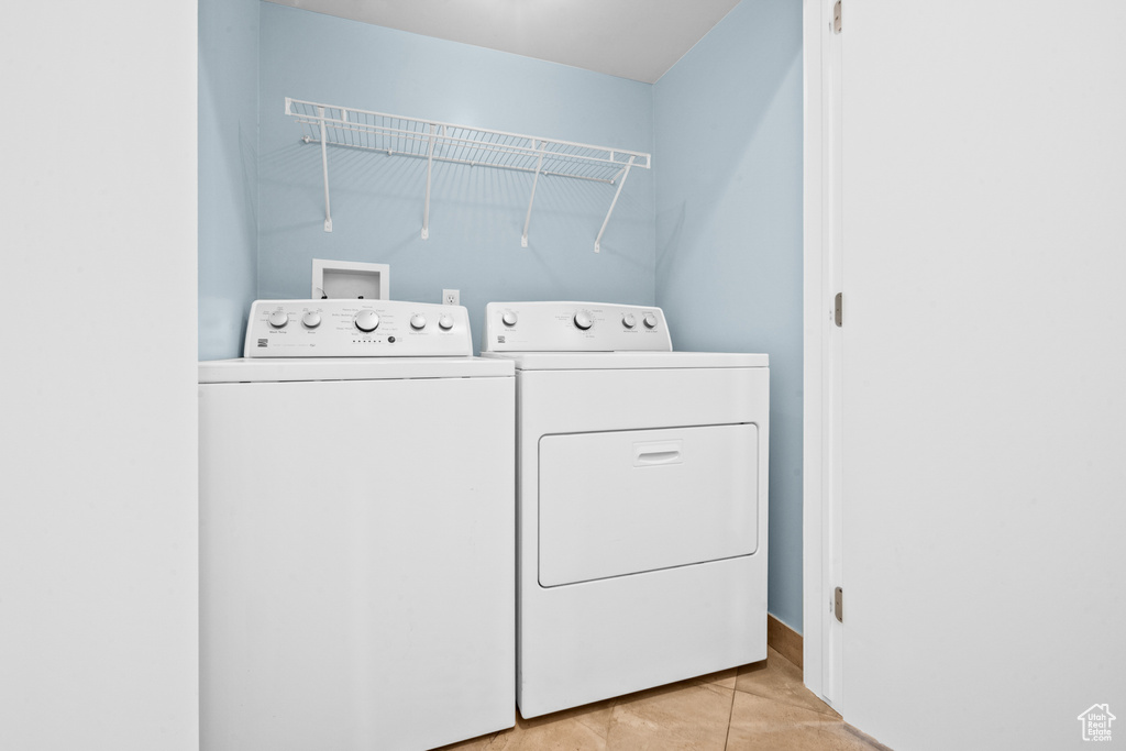 Laundry area featuring washer and clothes dryer and light tile patterned flooring