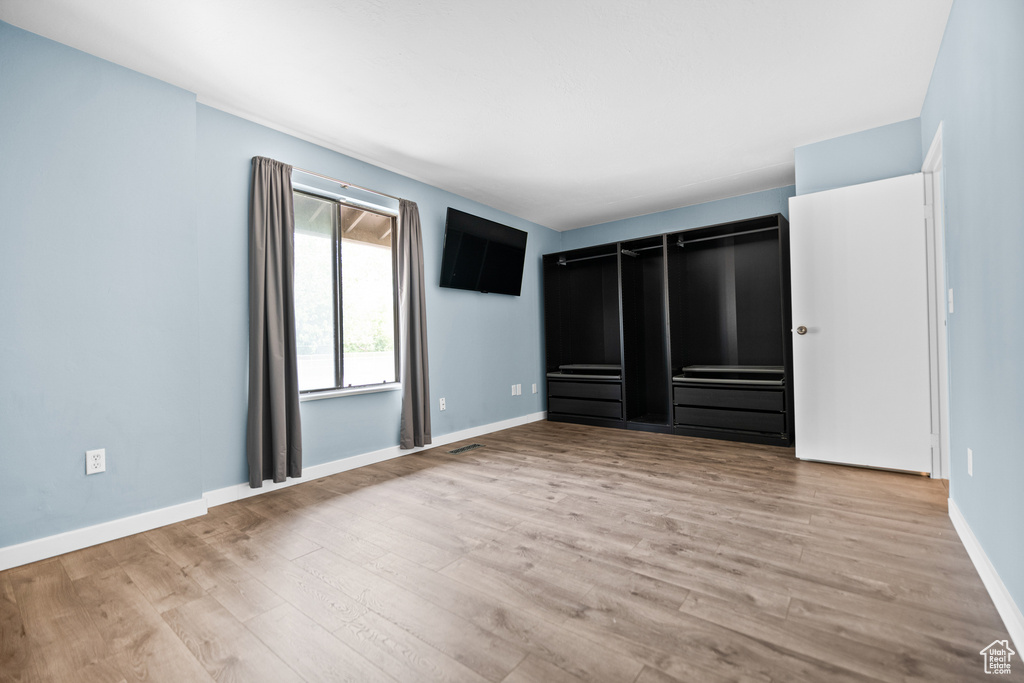 Unfurnished bedroom with wood finished floors and baseboards