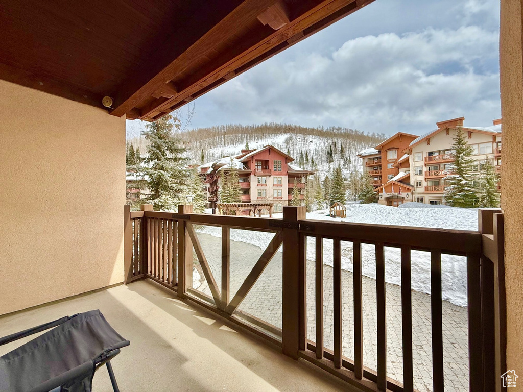 Snow covered back of property with a mountain view