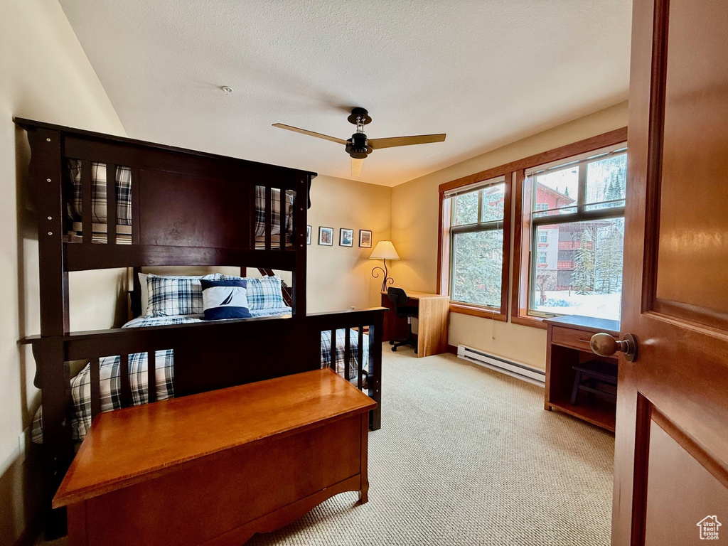 Bedroom with a baseboard radiator, ceiling fan, and carpet floors