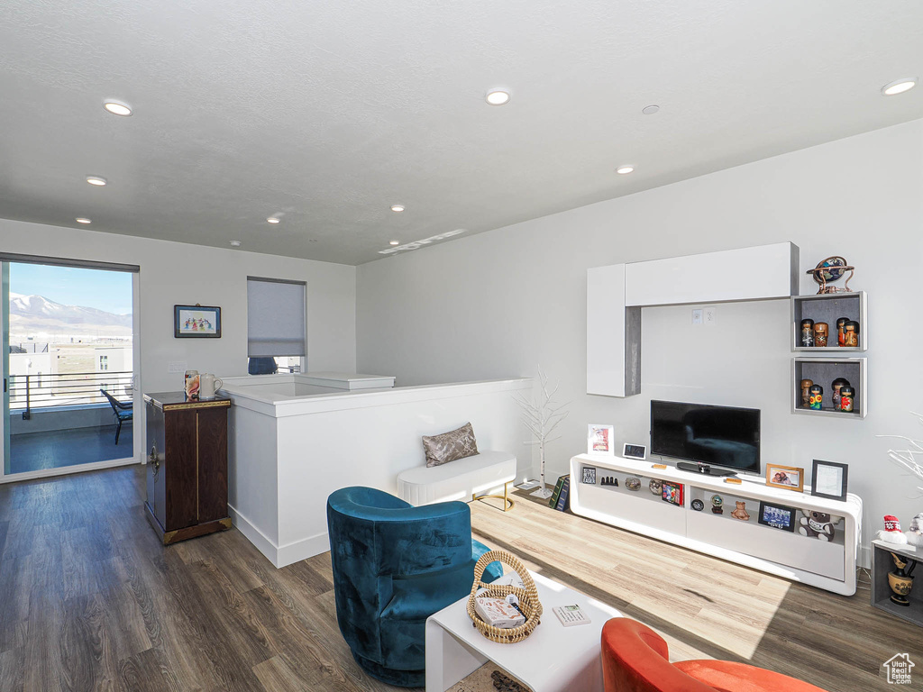 Living area with dark wood-type flooring, recessed lighting, and baseboards