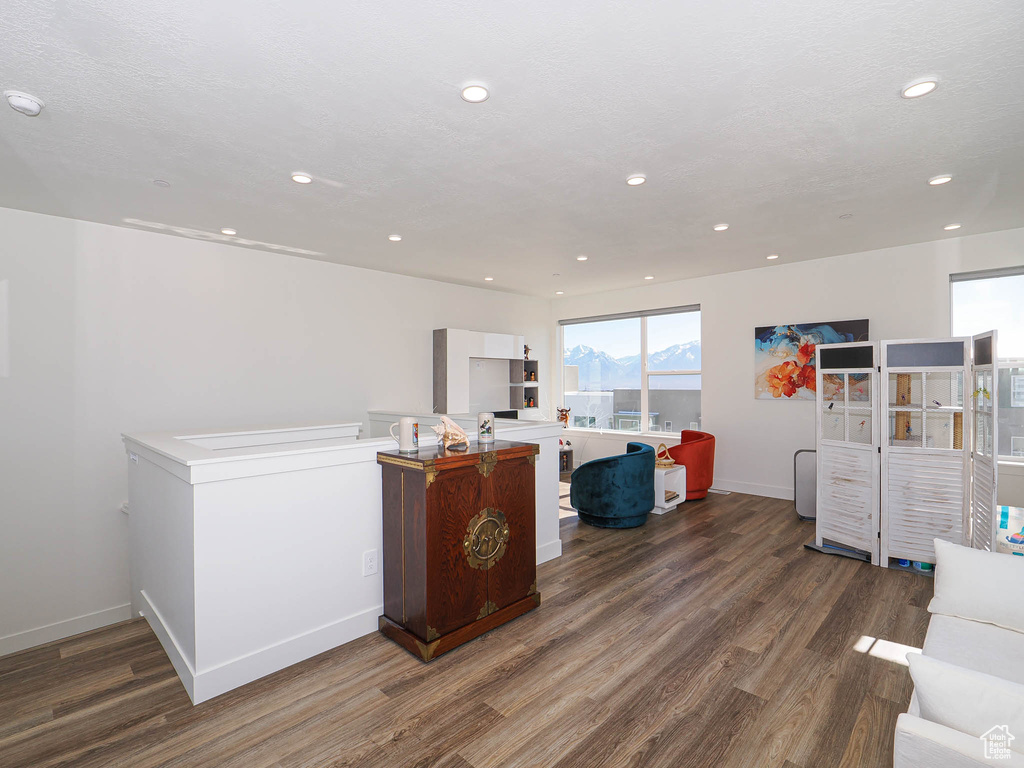 Living room with wood finished floors, recessed lighting, and baseboards
