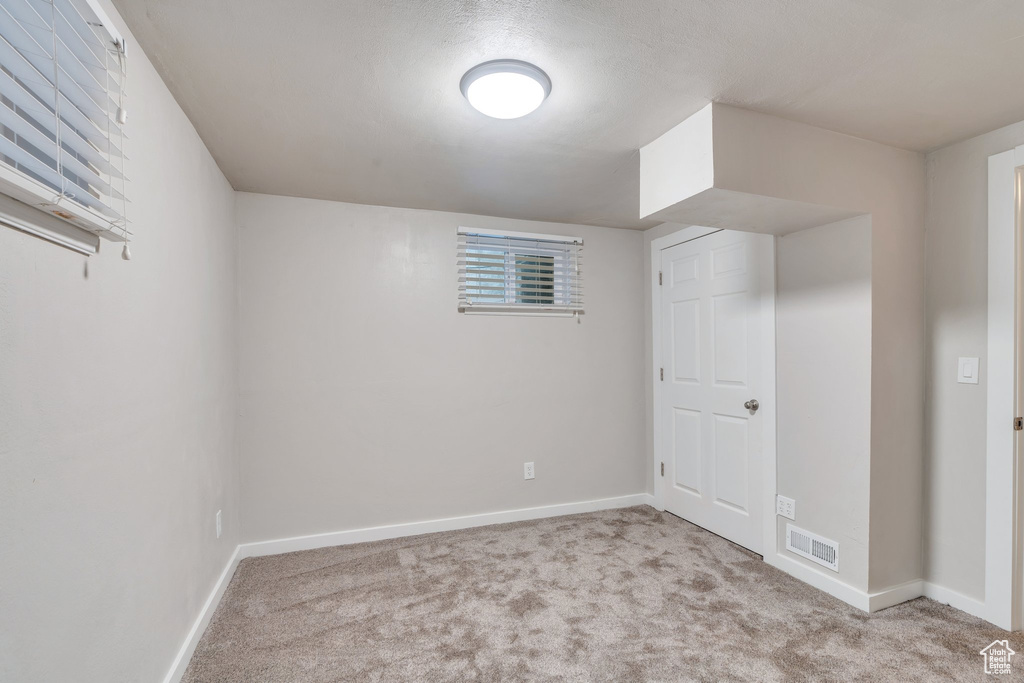 Carpeted empty room with baseboards and visible vents